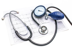 Stethoscope and  blood pressure gauge lying on the ECG chart