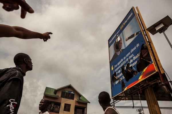 Demonstrators point a broken billboard showing the face of Congolese President Joseph Desiree Kabila during an opposition rally in Kinshasa on September 19, 2016.
Police fired tear gas at scores of opposition supporters rallying in Kinshasa to demand that DR Congo's long-serving President Joseph Kabila step down this year, AFP journalists said. Kabila, who has ruled DR Congo since 2001, is banned under the constitution from running again -- but he has given no sign of intending to give up his job in December. / AFP PHOTO / EDUARDO SOTERAS