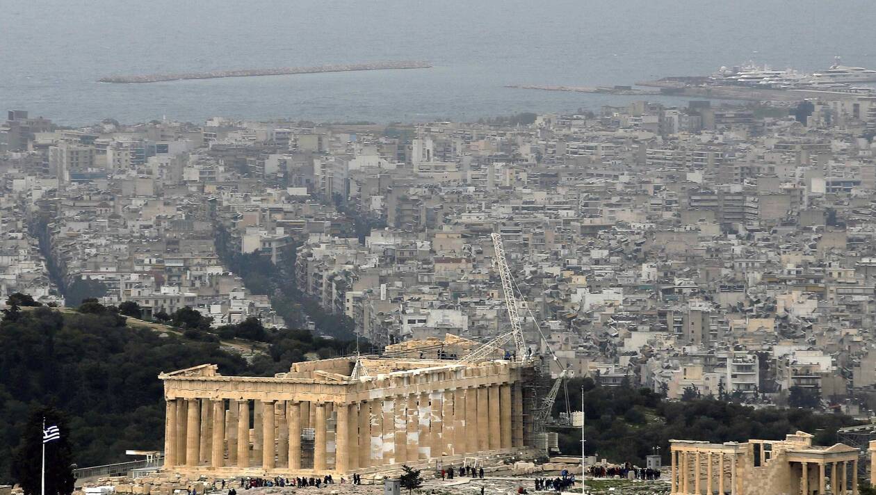 Part of modern Athens and its Saronic gulf is pictured as tourists visit the Acropolis in Athens March 6, 2015. Greece's central bank chief Yannis Stournaras said on Friday that the country's banks are sufficiently recapitalised and face no problem with deposit outflows.  REUTERS/Yannis Behrakis (GREECE - Tags: POLITICS BUSINESS SOCIETY)
