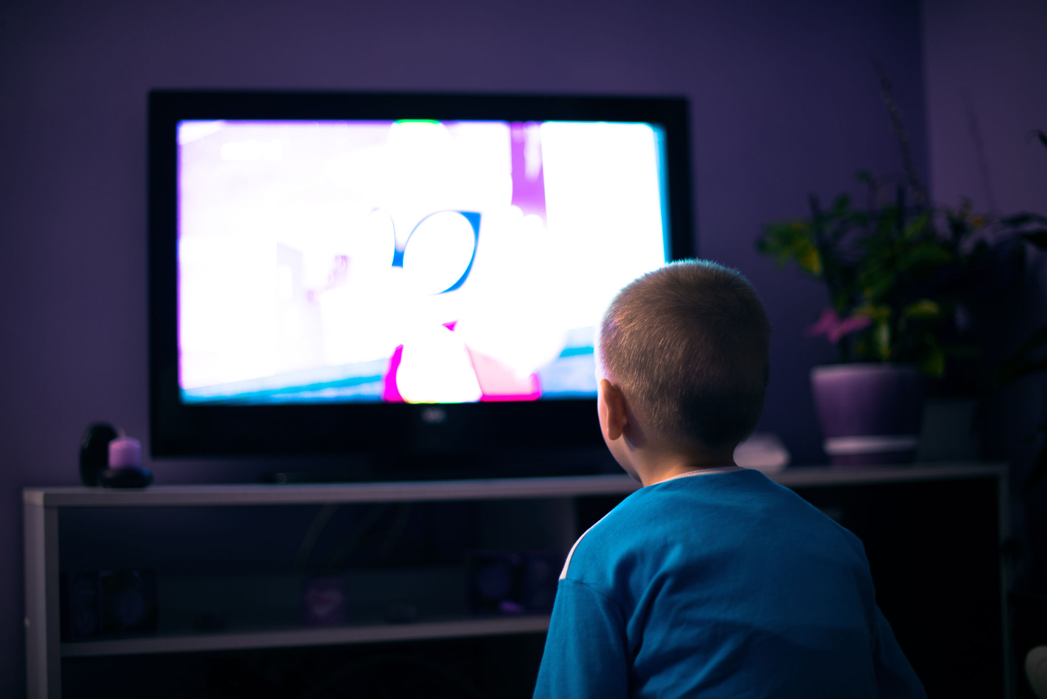 Boy watching television in dark living room