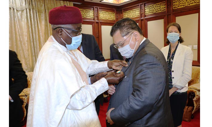 Le chef de la diplomatie nigérienne élevant Peter Pham au rand d'officier dans l’ordre du mérite du Niger.