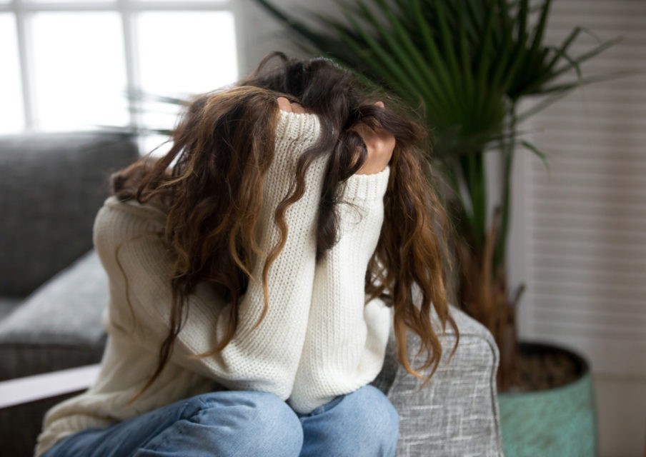 Young woman victim suffering from abuse, harassment, depression or heartbreak, sad desperate teenager having problems holding head in hands, heartbroken upset girl crying having dangerous addiction